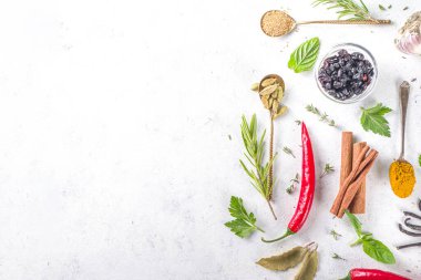 Taze bitkiler, kurutulmuş renkli baharatlar. Arka planda çeşitli baharatlar, bitkiler biber, vanilya fasulyesi, tarçın, fesleğen, biberiye, kırmızı biber, nane, maydanoz beyazından masa üstü manzaralı flatlay pişirme