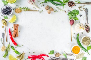 Taze bitkiler, kurutulmuş renkli baharatlar. Arka planda çeşitli baharatlar, bitkiler biber, vanilya fasulyesi, tarçın, fesleğen, biberiye, kırmızı biber, nane, maydanoz beyazından masa üstü manzaralı flatlay pişirme