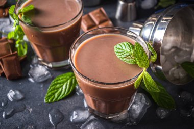 Buzlu çikolatalı kokteyl. Yaz serinletici içecekler. Buzlu, çikolatalı, hindistan cevizli içecek, latte kahve. Buzlu, naneli ve çikolata dilimli arka planda fotokopi alanı