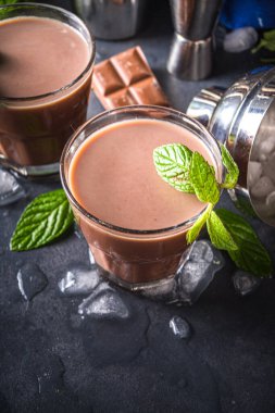 Buzlu çikolatalı kokteyl. Yaz serinletici içecekler. Buzlu, çikolatalı, hindistan cevizli içecek, latte kahve. Buzlu, naneli ve çikolata dilimli arka planda fotokopi alanı