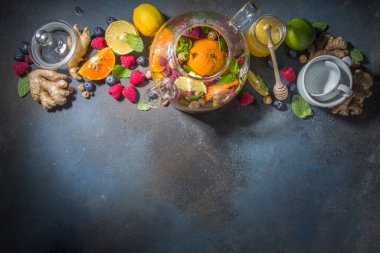 Çaydanlıkta meyve ve çilek çayı. Limonlu, naneli, yabanmersinli, zencefilli, portakallı, elmalı sıcak içecek. Koyu mavi arkaplan fotokopi alanında sıcak aromalı buhar içeceği  