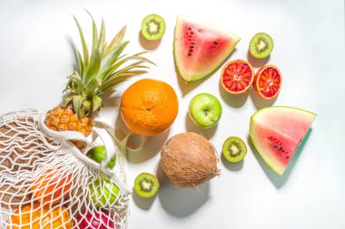 Yaz vejetaryeni ve sürdürülebilir alışveriş konsepti, taze tropikal meyvelerle dolu alışveriş torbası, arka planda beyaz masa fotokopi alanı