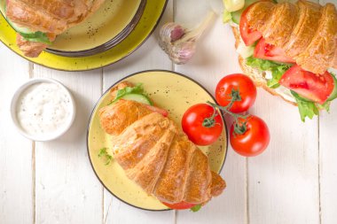 Taze sebzeli kruvasan sandviçi. Marul, domates, salatalık. Vitamin diyeti yaz veya bahar atıştırması, kahvaltı. Sarı arkaplan kopyalama alanı