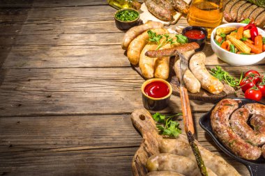 Kızarmış sosis çeşitleri. Bavyera, Frankfurt, Alman ızgara sosisleri, Oktoberfest ya da yaz barbekü partisi konsepti, eski ahşap masa arkaplan fotokopi alanı