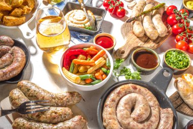 Kızarmış sosis çeşitleri. Bavyera, Frankfurt, Alman ızgara sosisleri, Oktoberfest veya yaz barbekü partisi konsepti, beyaz arka plan fotokopi alanı üst görünümü