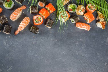Çubuklu suşi. Çeşitli lezzetli Japon suşileri, yuvarlanan parçalar ve açık mavi arka planda nigiri.