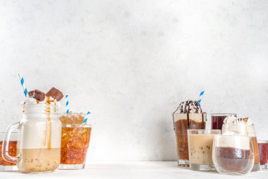 Farklı buzlu yaz kahve içecekleri - espresso, frappe, latte, cappuccino, kremalı, şuruplu ve ezilmiş buzlu, çeşitli bardaklarda ve kupalarda beyaz arka planda fotokopi alanı