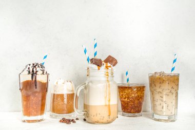 Farklı buzlu yaz kahve içecekleri - espresso, frappe, latte, cappuccino, kremalı, şuruplu ve ezilmiş buzlu, çeşitli bardaklarda ve kupalarda beyaz arka planda fotokopi alanı