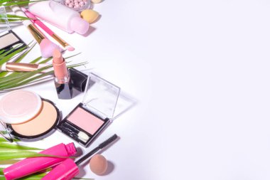 Yazın dekoratif makyaj seti, profesyonel makyaj ve beyaz arka planda palmiye yaprakları düz üst görünüm kopyalama alanı olan aksesuarlar