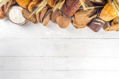 Beyaz arka planda çeşitli lezzetli, taze pişmiş ekmekler fotokopi alanı