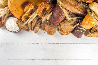 Beyaz arka planda çeşitli lezzetli, taze pişmiş ekmekler fotokopi alanı