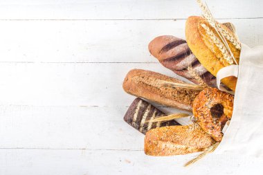 Beyaz arka planda çeşitli lezzetli, taze pişmiş ekmekler fotokopi alanı