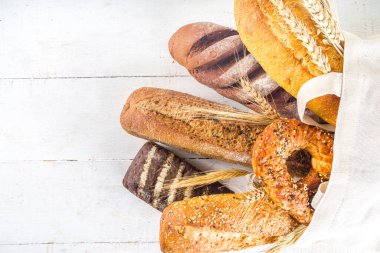 Beyaz arka planda çeşitli lezzetli, taze pişmiş ekmekler fotokopi alanı