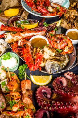 Çeşitli barbekü çeşitleri Akdeniz ızgara gıdaları - balık, ahtapot, karides, yengeç, deniz ürünleri, midye, yaz diyet bbq parti şenliği, kebap, sos, siyah beton arka plan, fotokopi alanının üstünde