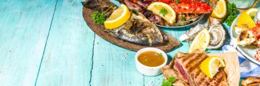 Çeşitli barbekü çeşitleri Akdeniz ızgara gıdaları - balık, ahtapot, karides, yengeç, deniz ürünleri, midye, yaz diyeti bbq parti festivali, kebap, soslar, açık mavi sunne ahşap arka plan