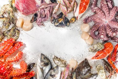 Çeşitli taze çiğ deniz ürünleri seti - ahtapot, yengeç, mürekkep balığı, karides, istiridye, midye, somon balığı limon baharatlı ton balığı, ezilmiş buzlu arka plan üst görünüm 