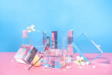 Güzellik bakımı, şeffaf cam kaidesi podyumlarında makyaj yapmak, bahar kiraz çiçekleri ile parlak pembe bir arka planda taklit yapmak. 