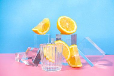 Renkli mavi arka planda parlak bir limonata cam kaideler taze meyveli podyumlar, kopyalama alanı 