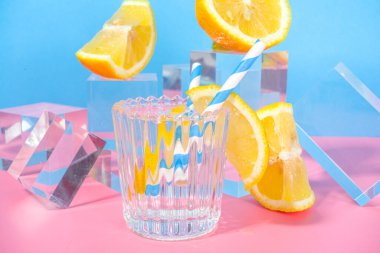 Renkli mavi arka planda parlak bir limonata cam kaideler taze meyveli podyumlar, kopyalama alanı 