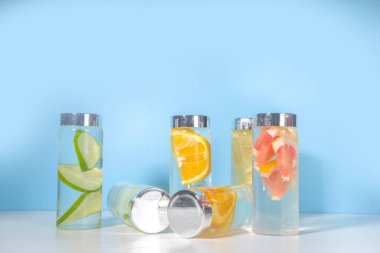 Şişe içinde çeşitli soğuk içecekler, yaz aşılamalı su şişeleri, limonata sağlıklı kokteyller limon, portakal, greyfurt, ıhlamur, parlak arka plan kopyalama alanı