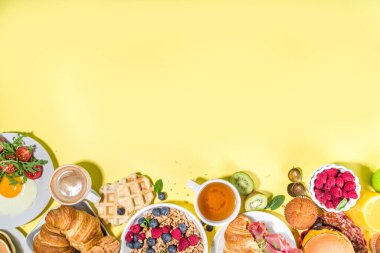 Çeşitli geleneksel kahvaltı yemekleri - domuz pastırmalı kızarmış yumurta, müsli, yulaf, waffle, gözleme, burger, kruvasan, meyve meyvesi, kahve, çay ve portakal suyu, sarı masa arkası fotokopi alanı