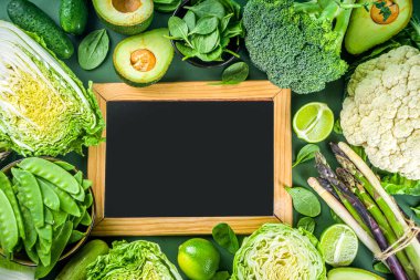 Sağlıklı diyet bahar yemekleri. Taze çiğ organik sebze çeşitleri - brokoli, karnabahar, kabak, salatalık, kuşkonmaz, ıspanak, avokado, koyu yeşil arka planda lahana.
