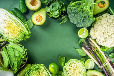 Sağlıklı diyet bahar yemekleri. Taze çiğ organik sebze çeşitleri - brokoli, karnabahar, kabak, salatalık, kuşkonmaz, ıspanak, avokado, koyu yeşil arka planda lahana.