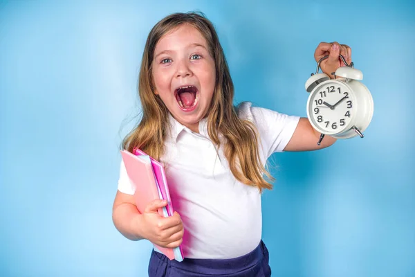 招待状 広告バナーに戻る 白い青い制服を着たかわいい小学生の女の子 目覚まし時計 学ぶ時間 学校の販売の概念 — ストック写真