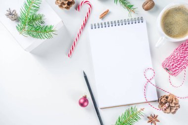Noel ve yeni yıl arkaplanı boş not defteri, kalem ve yılbaşı süslemeleri. Liste yapmak, dilek listesi konsepti. Model, çerçeve, düz çizgi
