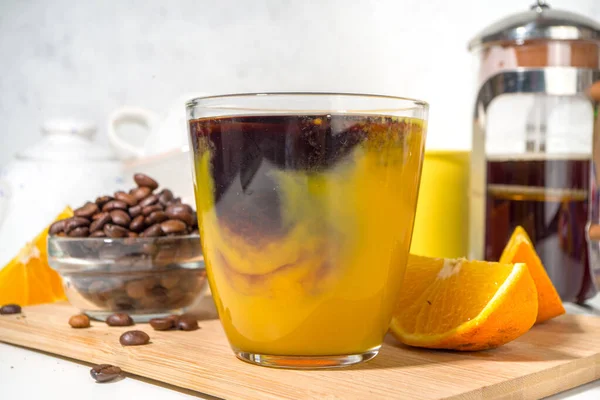 Bumble bee Coffee cocktail. Homemade hot drink with espresso and  orange juice, on white kitchen table copy space
