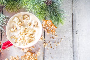 Patlamış mısır, sütlü kahve fincanı. Moda içeceği, tuzlu peynirli patlamış mısır, kış Noel süsü, beyaz ahşap arka plan fotokopi alanı.
