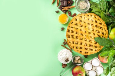  Sonbaharda elmalı turtayla pişirme arka planı. Geleneksel Amerikan elmalı turtası taze elmalar, tarçın, baharatlar, fırın malzemeleri, açık yeşil arka planda üst görünüm kopyalama alanı