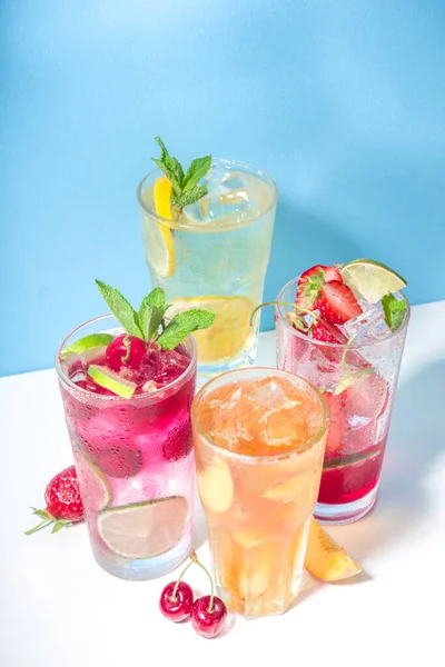 Iced refreshing drink. Bar and cafe beverage menu background. Set of various cold summer cocktails  - peach tea, lemonade, mojito, cherry mocktail, with fruits on colorful bright blue background