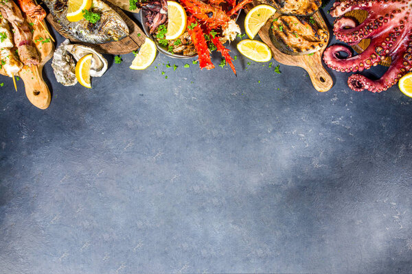 Assortment various barbecue Mediterranean grill food - fish, octopus, shrimp, crab, seafood, mussels, summer diet bbq party fest, with kebab, sauces, black concrete background, above copy space