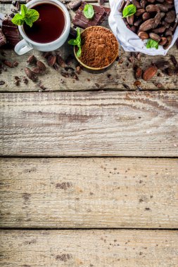 Kakaonun farklı koşulları. Çeşitli kakao - fasulye, fasulye, toprak, ezilmiş kakao tozu, çikolata ezmesi, çikolata parçaları ve sıcak çikolata. Metin için kopyalama alanı olan ahşap bir kırsal arkaplan üzerinde
