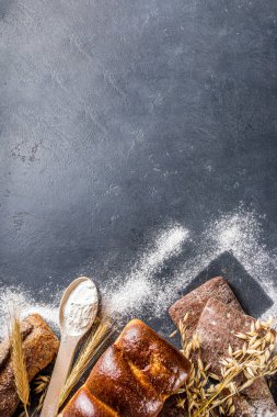 Çeşitli ekmek setleri. Birçok farklı buğday, tahıl ve çavdar ekmeği çavdar ve buğday, un ve fırıncı aletleriyle beyaz ahşap arka planda.