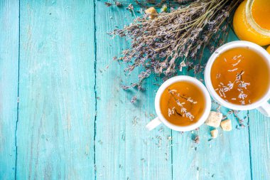 Aromatik lavantalı çay fincanı, lavanta demeti, bal ve limon, turkuaz ahşap arka plan fotokopi alanı