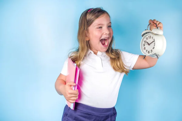 招待状 広告バナーに戻る 白い青い制服を着たかわいい小学生の女の子 目覚まし時計 学ぶ時間 学校の販売の概念 — ストック写真