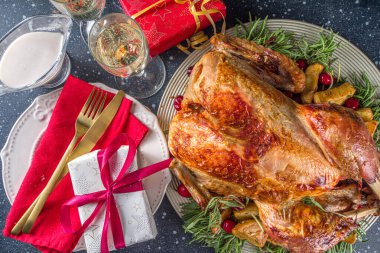 Noel ya da yeni yıl hindi yemeği. Fırında hindi, patates, kırmızı böğürtlen ve adaçayı, Noel yemeği masasında Noel ağacı, hediye ve mum.