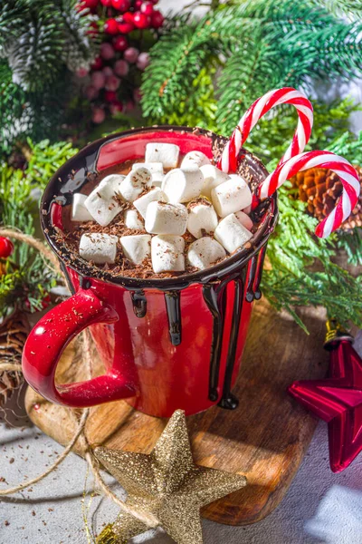 Homemade hot chocolate with mini marshmallows, hot cozy Christmas cocoa drink on wooden background with Xmas decorations copy space