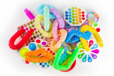 Modern trend çocuklar parmak oyuncakları, rahatlama konsepti - beyaz arka planda farklı parlak pop-it setleri, basit gamzeli, yumuşak, pop-tüpleri, üst görünüm kopyalama alanı