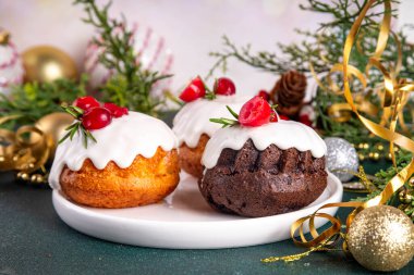 Porsiyonlu Noel çöreği, zencefilli çikolata ve vanilyalı mini noel pastası üzerine şeker sosu, kızılcık ve biberiye süslemesi.