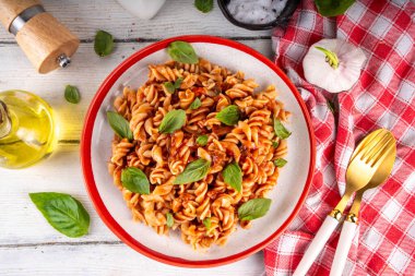 Bolonez soslu Fusilli makarna, kıyma, mantar, domates ve fesleğen. Geleneksel İtalyan yemek tabağı, masada servis edilen baharatlar.