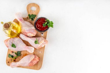 Tavuk eti hazırlama arka planı, ızgaraya hazır çiğ tavuk bacağı, baharatlar, tuz, biber, zeytinyağı, sarımsak ve salamura veya sos. Izgara ve bbq sezon pişirme arka planı, kopyalama alanı