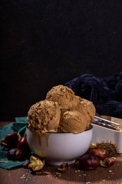 Baharatlı baharatlı dondurma, kavrulmuş kestane tadında, baharatlı, ahşap arka planda taze ve kavrulmuş kestane.