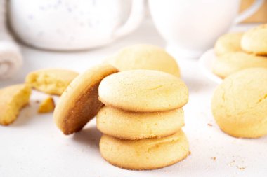 Ev yapımı kurabiyeler, geleneksel İngiliz çay partisi tereyağlı kurabiyeler, beyaz mutfak masasında tatlı kurabiyeler.