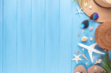 Yaz tatili ve hasır şapkalı, çantalı, terlikli, palmiye yapraklı, güneş gözlüklü, kameralı, deniz kabuklu ve okyanus yıldızlı tatil geçmişi. Plaj ve tropikal yaz tatili arka planı, üst görünüm kopyalama alanı