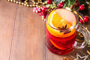Tatlı elma, portakal, bal, tarçın ve anason yıldızlı cam bardak, ahşap masa üzerinde Noel süsü, tatil içkisi. Sıcak baharatlı amber çayı, alkolsüz sıcak içecek.