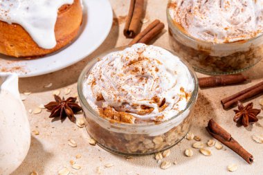 Lezzetli katmanlı tarçınlı rulo yulaf ezmesi. Kavanozdaki lezzetli yulaflar, lezzetli konforlu sabah yemekleri, Yunan yoğurt soslu tatlı sağlıklı atıştırmalıklar ve tarçınlı çörekler. 