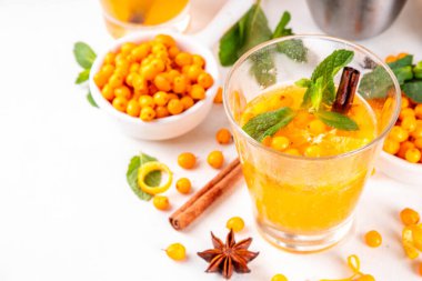 Ev yapımı deniz dikeni (hipopotam) sonbahar kokteyli, taze böğürtlenli soğuk içecek, tarçın baharatları, bal, portakal ve nane aromalı, beyaz arka plan fotokopi alanı